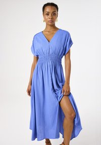 Blaues, knöpfbares Maxikleid mit V-Ausschnitt, geraffter Taille und kurzen Ärmeln. Verfügt über einen seitlichen Schlitz und weichen, strukturierten Stoff.