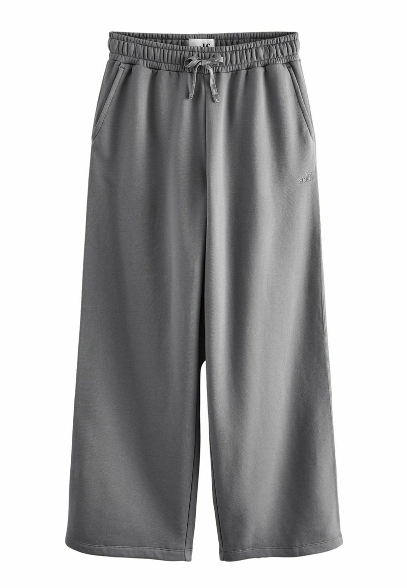 Pantalones de chándal grises, hasta la rodilla, fabricados en tejido suave, con una cinturilla elástica y cordón de ajuste, y bolsillos laterales.