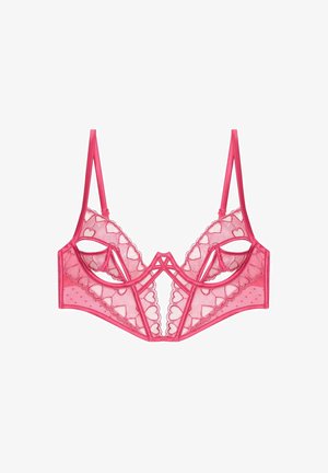 Bralette in pizzo rosa con ritagli a forma di cuore, spalline regolabili, texture a pois e bordi smerlati. Design leggero e trasparente.