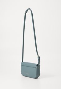 Keresztbody táska puha, texturált kék-szürke anyagból. Téglalap alakú, fedélzárral és állítható pánttal, minimalista arany logóval.