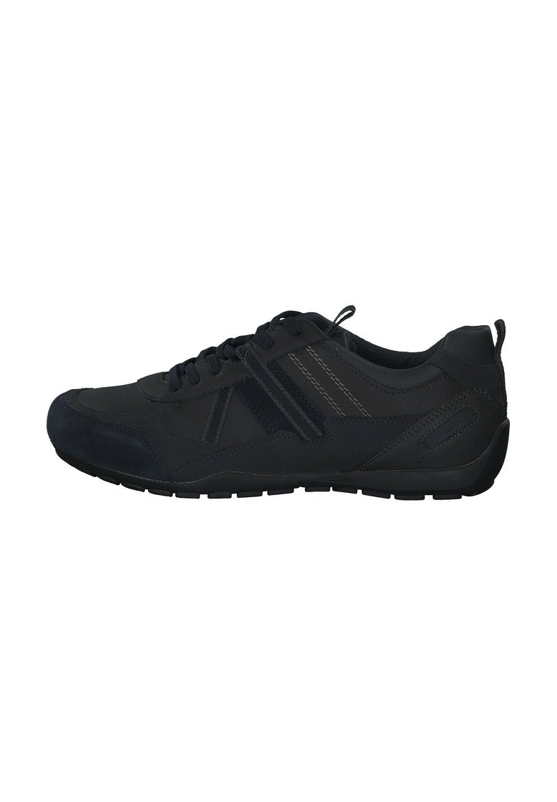 Black athletic shoe featuring synthetic upper, mesh accents, lace closure, and textured rubber sole. Minimalist design with subtle stitching details.