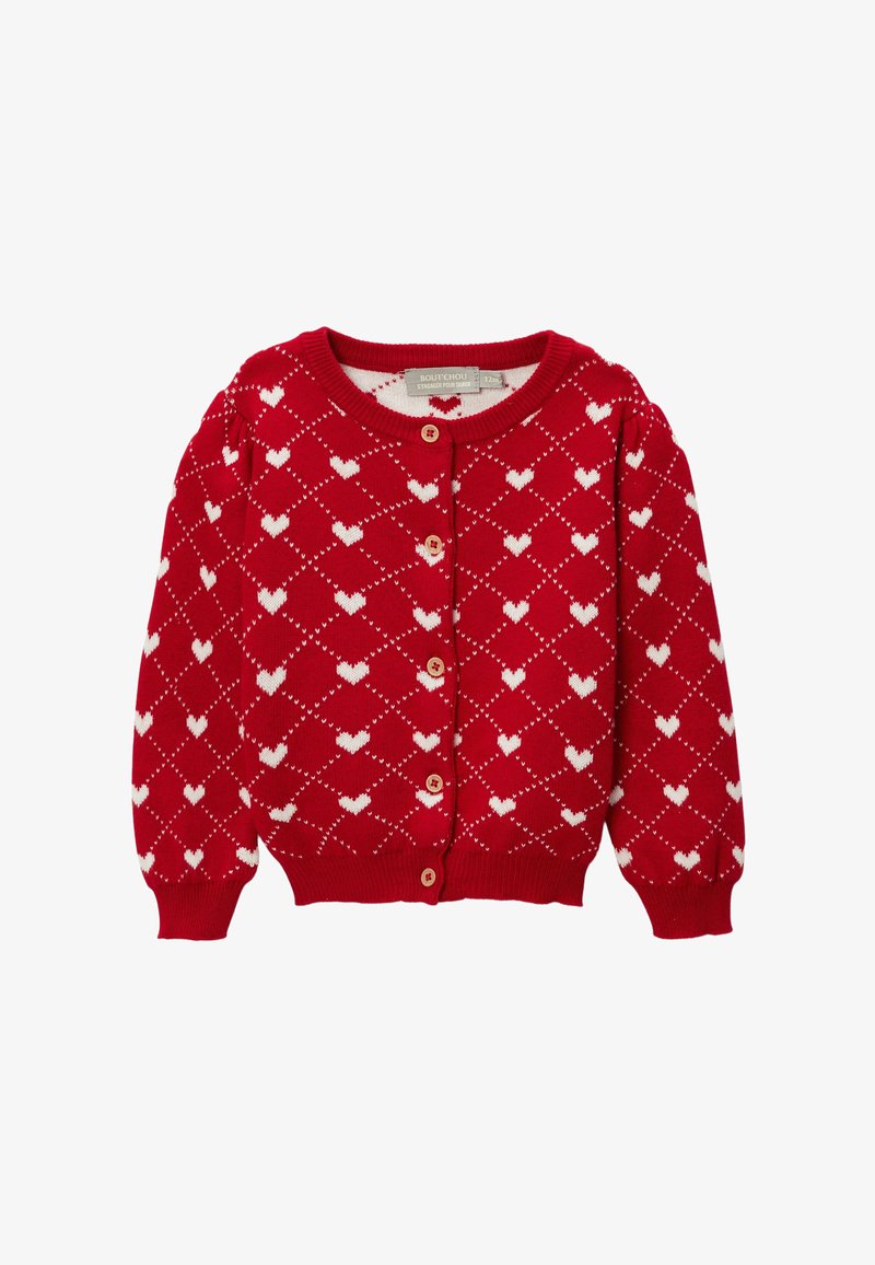 Cardigan rouge en tissu tricoté, présentant un motif de cœurs blancs sur toute la surface, un col arrondi et une fermeture boutonnée avec des boutons en bois.