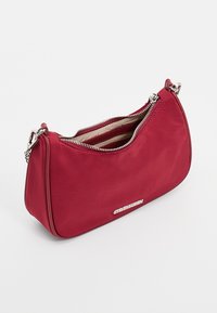 Rød nylon håndtaske med en buet form, top zip lukning og hardware i sølvfarve. Har et foret interiør med lodrette striber.