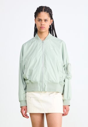 Light green bomber jacket made of smooth fabric, featuring ribbed cuffs and hem, zip closure, and a side pocket with a flap.