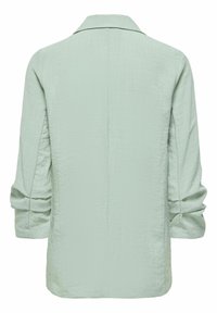 Blazer vert clair à manches longues en tissu texturé avec poignets pliés, vu de dos.