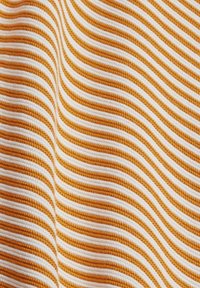 Textil mit abwechselnden wellenförmigen Streifen in Orange und Weiß. Der Stoff hat eine strukturierte Oberfläche, die seine haptische Qualität verstärkt.