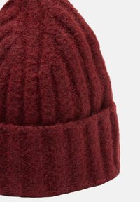 Berretto lavorato a maglia rosso realizzato in morbida lana, con texture a coste verticali e orlo ripiegato per una vestibilità aderente.