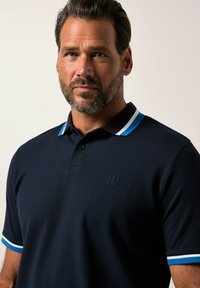 Navy polo shirt with a solid texture, featuring a two-toned collar with blue and white stripes and an embroidered logo on the chest.