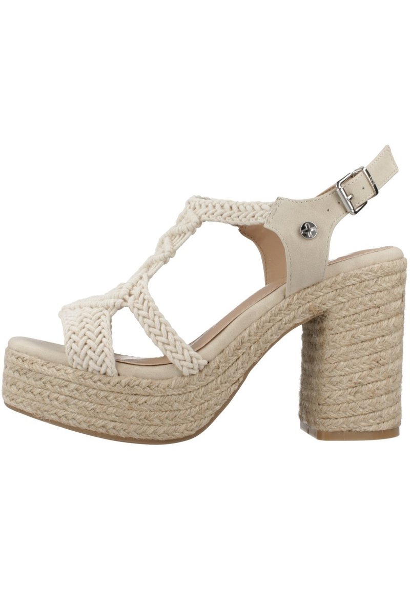 Sandal de color beige claro con tiras de tela trenzada, punta abierta y hebilla en el tobillo; cuenta con una gruesa plataforma de cuerda trenzada y un tacón cuadrado.