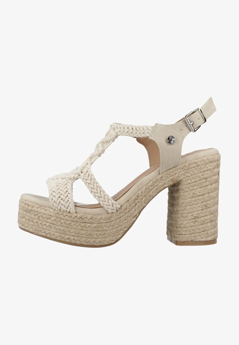 Sandal de color beige claro con tiras de tela trenzada, punta abierta y hebilla en el tobillo; cuenta con una gruesa plataforma de cuerda trenzada y un tacón cuadrado.