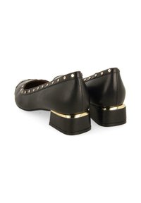 Bailarinas de cuero negro con punta redonda, adornadas con tachuelas doradas a lo largo del borde y un tacón cuadrado corto con un acento dorado en la base.