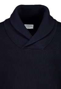 Dunkelblauer gestrickter Pullover mit Schalkragen, ausgestattet mit gerippter Textur und einem lockeren Schnitt. Etikett im Nacken sichtbar.