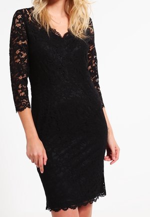 Robe en dentelle noire avec des manches trois-quarts. Présente un décolleté en V et un ourlet à bords festonnés. Un motif de dentelle florale texturée améliore le design.
