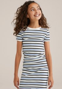 Svītrainas ribotas kleitas balta krāsā, ar šaurām horizontālām melnām un zilu svītrām. Īsas piedurknes; vidēja garuma piegriezums ar pieguļošu dizainu.