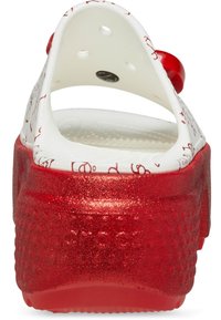 Weiße Schaumstoffclogs mit rotem Glitzer-Plateau, ausgestattet mit einem Rückriemen und Belüftungslöchern. Dekorativer Text auf dem Obermaterial aufgedruckt.