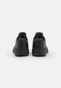 Sneaker sportive nere con tomaia in pelle liscia, colletto imbottito e suola in gomma testurizzata. Presentano logo impresso e cuciture rinforzate.