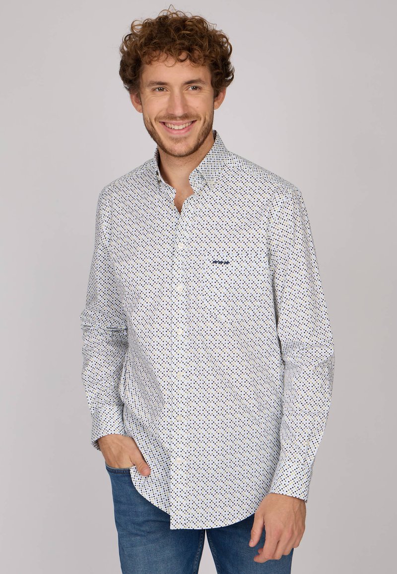 Chemise blanche à boutons avec un motif géométrique bleu marine et vert. Fabriquée dans un tissu léger, elle possède des manches longues et un col classique.