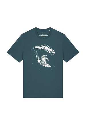 T-shirt bleu sarcelle foncé avec un graphisme blanc d’un astronaute surfant sur une vague faite d’étoiles et de tourbillons cosmiques.