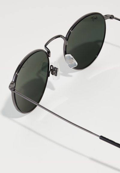 Ochelari de soare rotunzi cu lentile verzi închise, ramă subțire din metal negru, tampoane nazale ajustabile și temple elegante pentru confort.