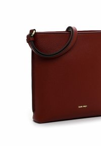 Borsa in pelle rossa con finitura testurizzata, forma rettangolare piatta e manico arrotondato. Presenta il marchio dorato sul davanti.