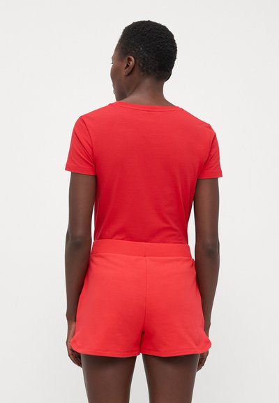 T-shirt rossa con maniche corte e scollatura tonda, abbinata a pantaloni corti rossi coordinati. Tessuto morbido con una consistenza liscia e cintura elastica.