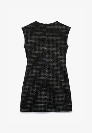 Sort ærmeløs kjole med et ternet mønster. Den strukturerede stof har hvide linjer, der danner firkanter. Rund halsudskæring og lynlås i midten bagpå.