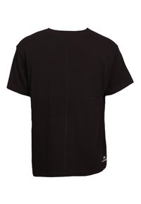 T-shirt noir à manches courtes avec col rond, couture centrale visible dans le dos, et petit logo blanc près de l'ourlet inférieur côté droit.