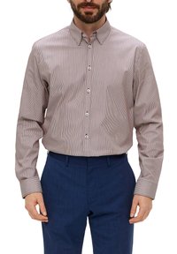 Rood-witte gestreepte shirt met knopen en een kraag, lange mouwen en een relaxte pasvorm. Geverfd stof; gecombineerd met marineblauwe broek.