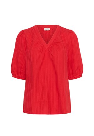 Raudona glamžyta bliuska su V formos iškirpte, trumpomis pūstomis rankovėmis ir laisvu siluetu. Išsiskiria tekstūruota medžiaga, suteikiančia papildomą dimensiją.