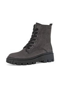 Zwarte suedine enkellaarsjes met een chunky zool, ronde neus en stevige vetersluiting. Voorzien van versterkte stiksels en een trekhaak aan de hiel.