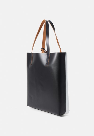 Sac fourre-tout noir au fini lisse, avec des poignées en cuir marron et une forme rectangulaire. La vue latérale montre une forme structurée et un design minimal.