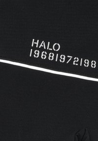 Svart tyg med vit text som säger "HALO" följt av siffrorna "19681972198," med en tunn vit linje över materialet.