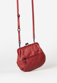 Rote Leder-Umhängetasche mit runder Form, plissiertem Design, verstellbarem Tragegurt und einer vorderen Reißverschlusstasche. Mit schwarzen Hardware-Akzenten.