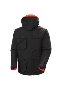 Chaqueta aislante negra con cierre de cremallera y botón, múltiples bolsillos frontales, y capucha y puños con forro naranja. Presenta una marca texturizada.