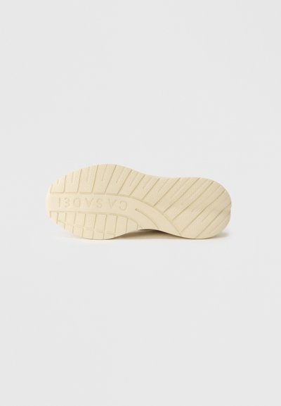 Σόλα παπουτσιού σε ανοιχτό μπεζ χρώμα, με υφή επιφάνειας που έχει αυλακώσεις και το λογότυπο "CASCADE" ανάγλυφο στο πλάι.