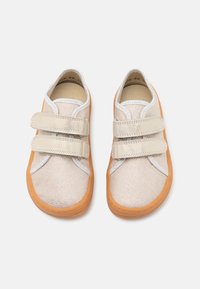 Scarpe in tela beige con due cinturini in velcro, cuciture grigie e una suola in gomma arancione. Design con punta tondeggiante, materiale superiore testurizzato.