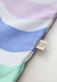 Zachte badstof met pastelkleurige horizontale strepen in paars, wit, blauw en groen, voorzien van een klein merklabel "Little Bird".