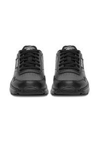 Czarne skórzane trampki z gumową podeszwą, wyposażone w czarne sznurowadła, perforowany wzór na nosku oraz akcenty z logo Reebok po bokach.