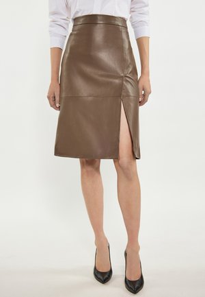 Gonna a matita in pelle marrone con vita alta, caratterizzata da uno spacco laterale e una texture liscia, abbinata a tacchi a punta nera.