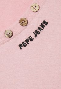 Lys rosa bomulls T-skjorte med V-hals, med tre dekorative brune knapper og "PEPE JEANS" brodert i svart.
