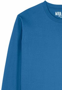 Chemise à manches longues en bleu vif, réalisée en tissu doux avec un col rond et une finition soignée. Présente une étiquette de la marque au niveau du col.