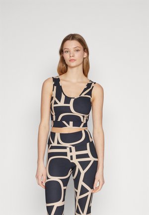 Navy and beige activewear set featuring a cropped top with a rounded neckline and high-waisted leggings with geometric patterns.