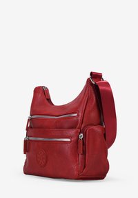 Bolso de hombro de cuero rojo con dos bolsillos frontales con cremallera, superficie texturizada, correa ajustable y detalle de logo circular en el costado.
