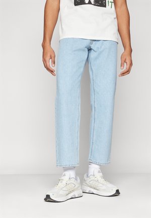 Lyseblå straight-leg jeans lavet af denim, parret med hvide sportsko. Funker inkluderer en afslappet pasform og et rent, minimalistisk design.