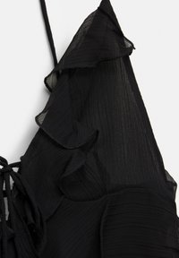 Black dress with ruffled details and adjustable straps. Made from lightweight, textured fabric with a layered design.