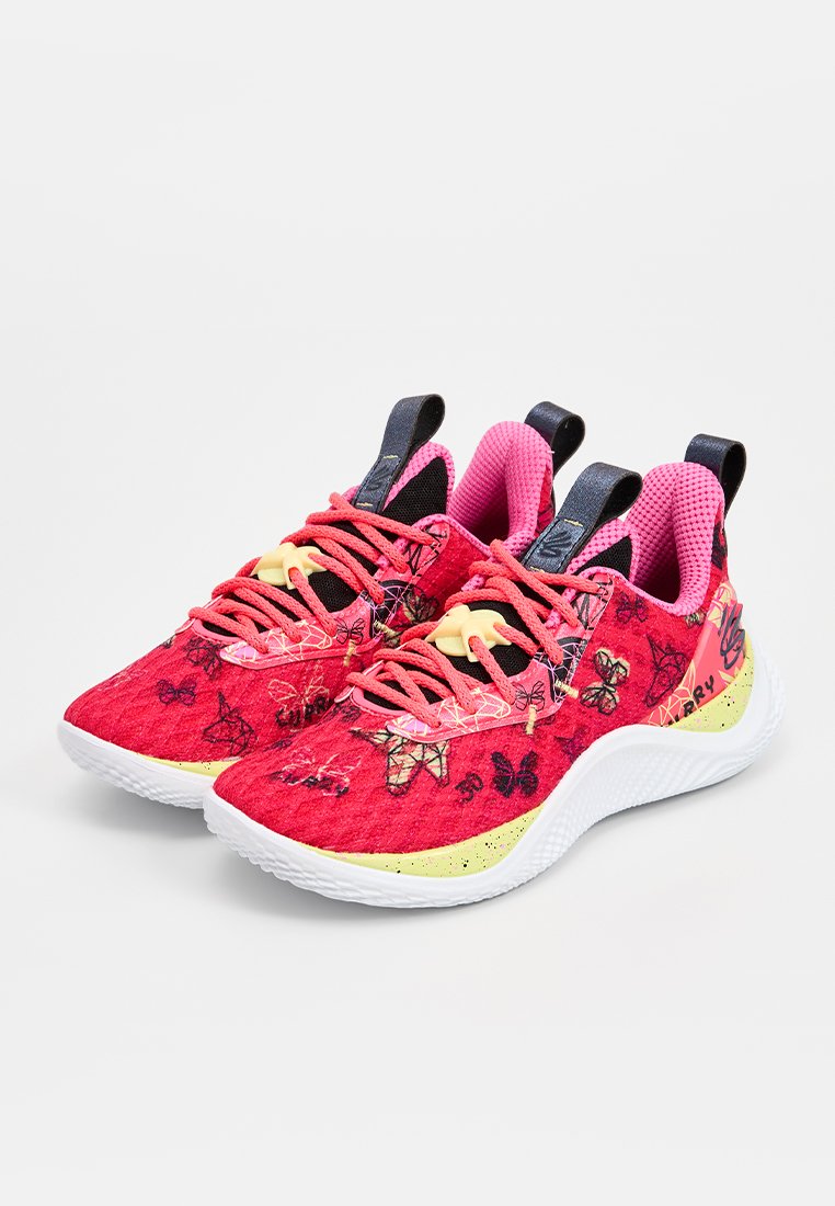 Baskets de sport rose vif avec des motifs de papillons, en tissu texturé, accents noirs, et une semelle rembourrée avec un détail jaune.