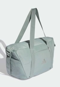 Lysegrøn duffelbag med justerbare stropper, lynlåslukket hovedrum og en lomme foran. Har et diskret logo på siden.