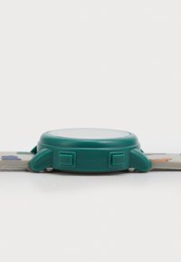 Montre en plastique vert avec un cadran rond et deux boutons. Le bracelet gris présente des illustrations colorées d'animaux. Texture lisse et design minimal.