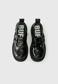 Černé kožené boty s hladkým povrchem, dvojicí přezek a silnou černou gumovou podrážkou s výrazným logem na stélce.