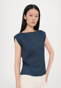 Navyblauwe geribde top met een ronde hals, korte mouwen en een relaxed fit. De stof heeft een gestructureerde uitstraling, met een licht gebogen zoom.